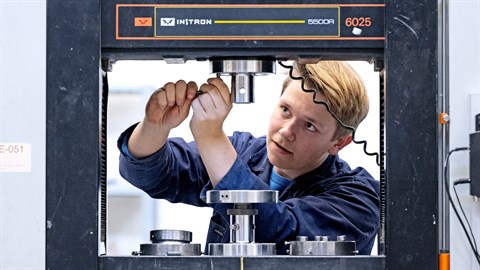 Ingeniør skruer på trykmaskine til test af lerbeton.
